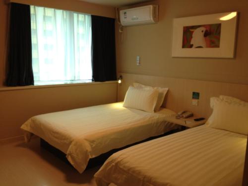 a hotel room with two beds and a window at Jinjiang Inn - Shanghai Songjiang University Town in Songjiang