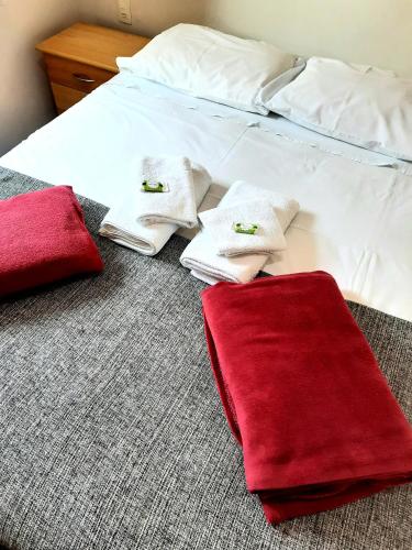 a bed with red and white towels on it at Hotel Vila Solar in Limeira