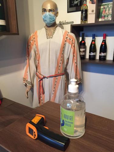 a mannequin wearing a mask next to a bottle of alcohol at Casa Dudu in Moieciu de Jos