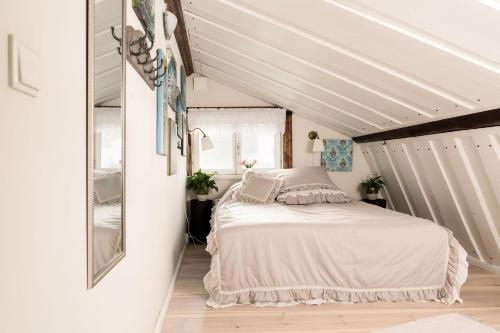 Schlafzimmer mit einem Bett und einem Spiegel in der Unterkunft ForRest unikt designat hus mitt i skogen in Alfta