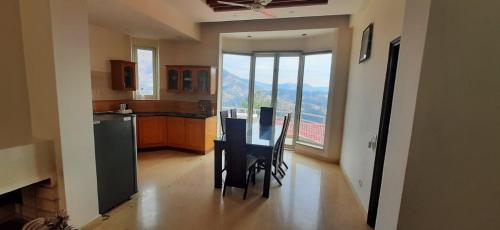 a kitchen and dining room with a table and chairs at amravati resort in Solan