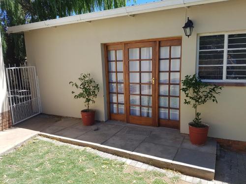 a front door of a house with two potted plants at Fig Tree in Colesberg
