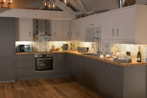 a kitchen with white cabinets and a counter top at Stownes in Stow on the Wold