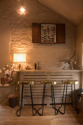a kitchen with two bar stools and a counter at Stownes in Stow on the Wold