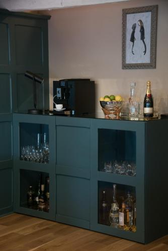 a blue cabinet with alcohol bottles and glasses at Stownes in Stow on the Wold