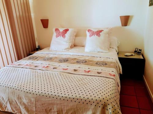 una camera da letto con un letto con cuscini e ciotole rosa di Le coup de coeur a Saint-François