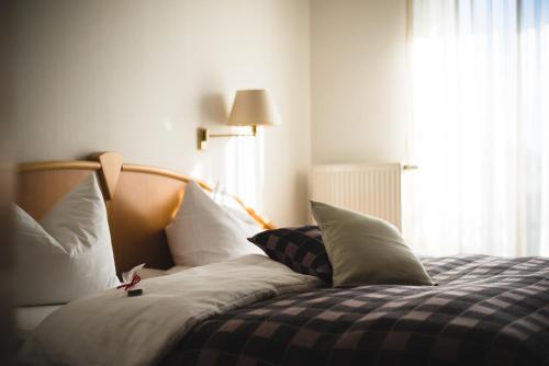 a bedroom with a bed with pillows and a window at Engelberg 24h check in in Wangen im Allgäu