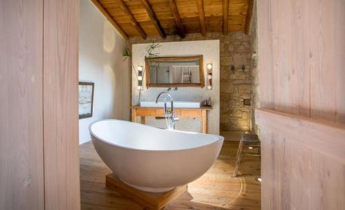a white bath tub in a bathroom with a mirror at Casa Mia in Fasoula