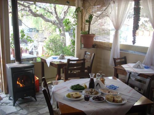 a table with food and a fireplace in a restaurant at Sivas Apartments-Studios,Sigelakis with very nice view in Sívas