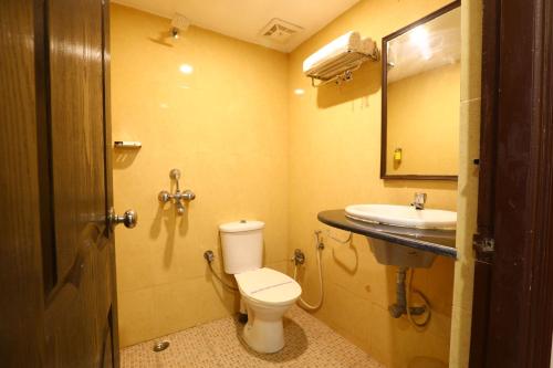 a bathroom with a toilet and a sink at Hotel Sona in Panaji