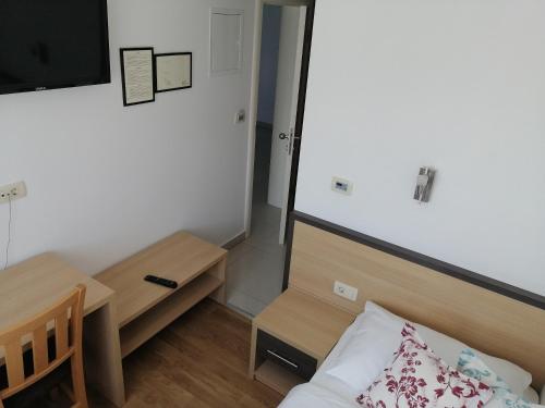 a small room with a bed and a table and a tv at Hotel Dina in Međugorje