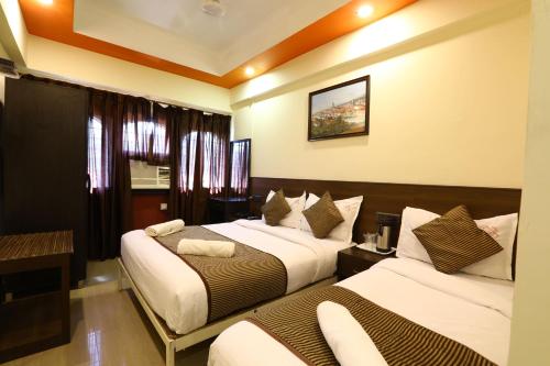 a hotel room with two beds in a room at Hotel Sona in Panaji