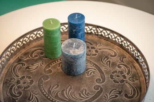 drie kaarsen op een bord op een tafel bij Studio Augusta in Den Burg