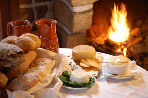 a pile of bread and cheese next to a fireplace at Agro-Turismo - Quinta do Pinheiro in Cavadoude