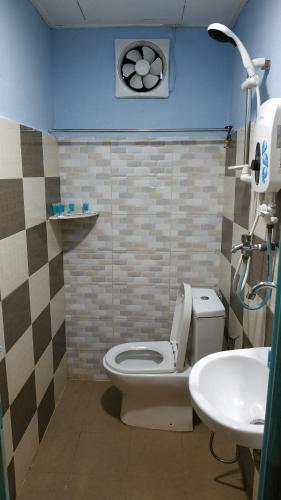a bathroom with a toilet and a sink at Niyaz Inn in Pantai Cenang