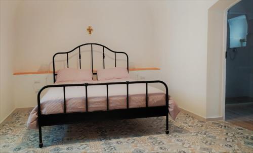 カノーザ・ディ・プーリアにあるDimora storica a Canosa di Pugliaの黒いベッド(ピンクの枕付)
