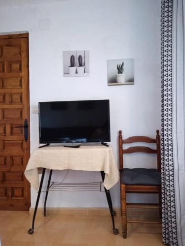 a television on a table in a room with a chair at An'Ca' La Pura in Villanueva del Conde