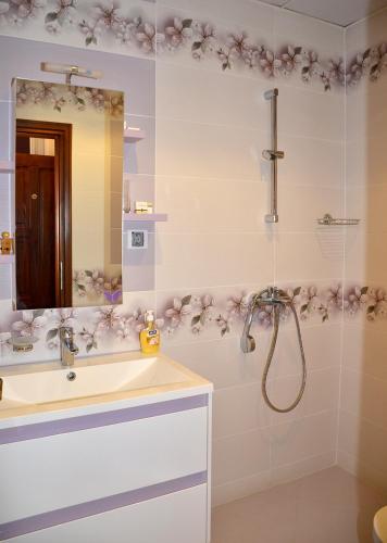 a bathroom with a shower and a sink and a mirror at Къщи за гости "КАРАТА" 2 in Devin