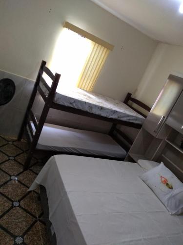 a room with two bunk beds and a window at Casa da Sua Família in Mucugê