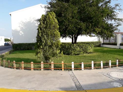 a fence on the side of a street with a tree at AIRPORT SHORT & LONG TERM EXPRESS ALMERIA x in Monterrey