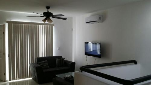 a living room with a couch and a ceiling fan at AIRPORT SHORT & LONG TERM EXPRESS ALMERIA x in Monterrey