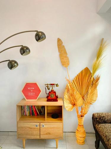 a room with a table with a vase and a plant at Rumah Sorai in Batu