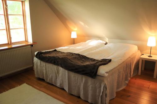 Bett in einem Zimmer mit zwei Lampen und einem Fenster in der Unterkunft Brösarps Norra Backar in Brösarp