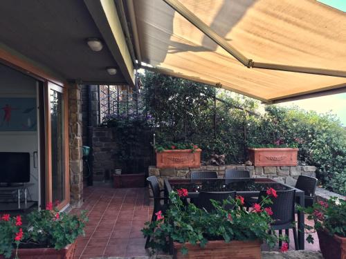a patio with a table and chairs and flowers at Panoramic Apartment Poggettone Air conditioned in Punta Ala