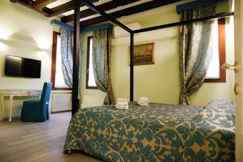 a bedroom with a bed and a desk and windows at Ca' Corazzeri in Venice