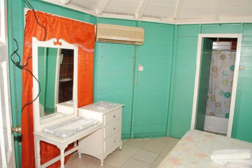 a bathroom with a mirror and a sink and a bed at Bluefields on the Bay in Good Hope