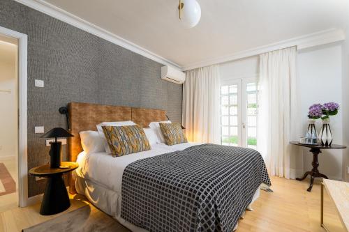 a bedroom with a bed with a black and white blanket at Hotel Boutique San Diego - Adults Only in La Laguna