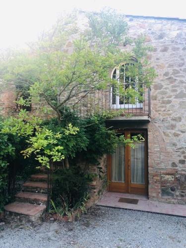 a brick building with a wooden door and a window at La Magnolia in Greve in Chianti