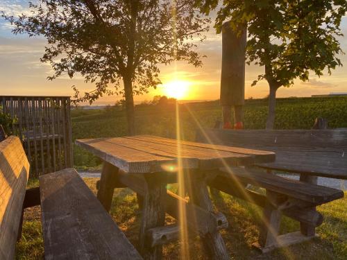 a wooden picnic table with the sunset in the background at Cottage Gols in Gols