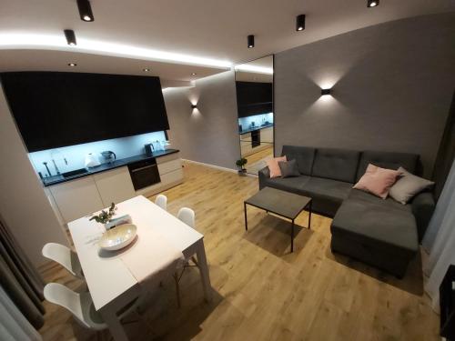 uma sala de estar com um sofá e uma mesa em DOBRY MOMENT - apartament Giżycko em Giżycko