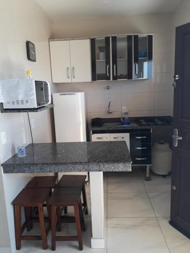 a kitchen with a counter and a refrigerator at Morada do Sol in Ilha Comprida