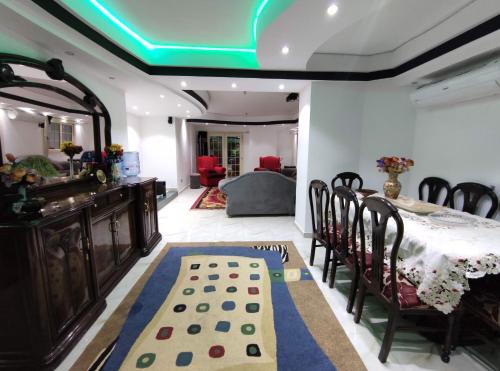 uma sala de jantar com uma mesa e cadeiras e um tecto verde em Luxury Apartments no Cairo