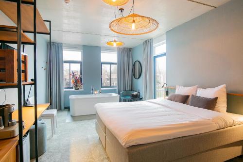 - une chambre avec un grand lit et une salle de bains dans l'établissement Hotel Marktstad, à Schagen