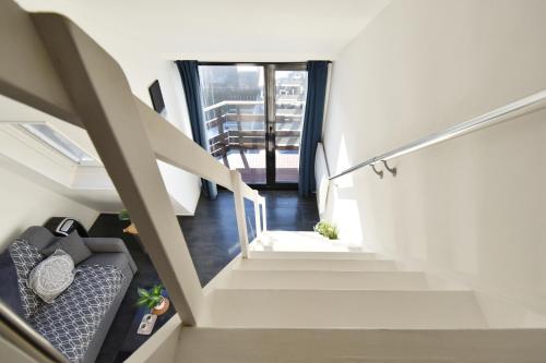 - un escalier dans une maison avec un canapé dans l'établissement Mini DUPLEX VUE MER EXPOSITION SUD, à Deauville