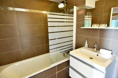 une salle de bain avec un lavabo, une baignoire et une douche dans l'établissement Mini DUPLEX VUE MER EXPOSITION SUD, à Deauville