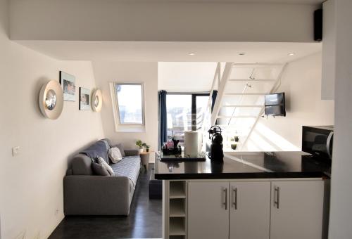 une cuisine et un salon avec un canapé et une table dans l'établissement Mini DUPLEX VUE MER EXPOSITION SUD, à Deauville