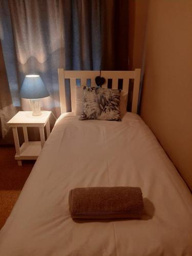 a large white bed with a brown towel on it at Dagbreek in Beaufort West