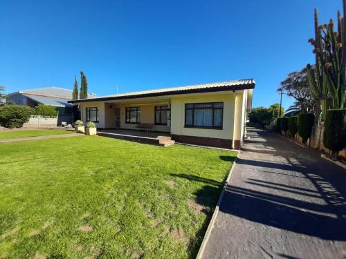 a house with a green lawn in front of it at Dagbreek in Beaufort West
