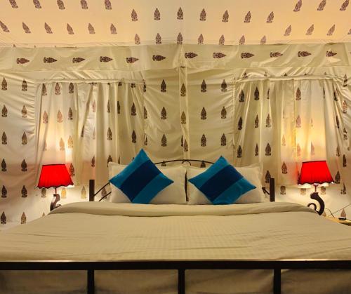 a bedroom with a large bed with two lamps at Agra Camps and Resort in Agra