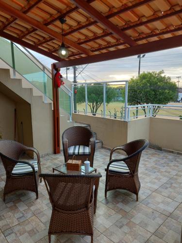 um pátio com cadeiras de vime e uma mesa no pátio em Pôr do sol apartamentos em Fortaleza