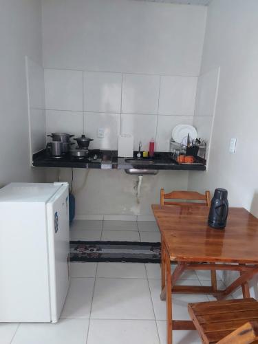 a small kitchen with a table and a refrigerator at Pôr do sol apartamentos in Fortaleza