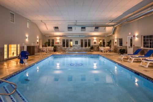 a large swimming pool with blue water in a building at Country Inn at Camden Rockport in Rockport