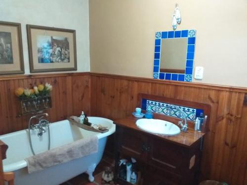 a bathroom with a tub and a sink and a bath tub at Sol Y Sombra in Bettyʼs Bay