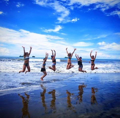 a group of women jumping in the water on the beach at Mango Tree Villas in Coronado