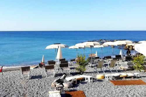 grupa leżaków i parasoli na plaży w obiekcie il piccolo loft w mieście Ventimiglia