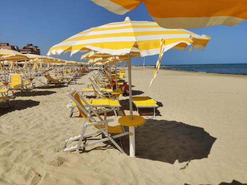 a bunch of chairs and umbrellas on a beach at Casa Martin , 4 bedroom villa in Bisenti